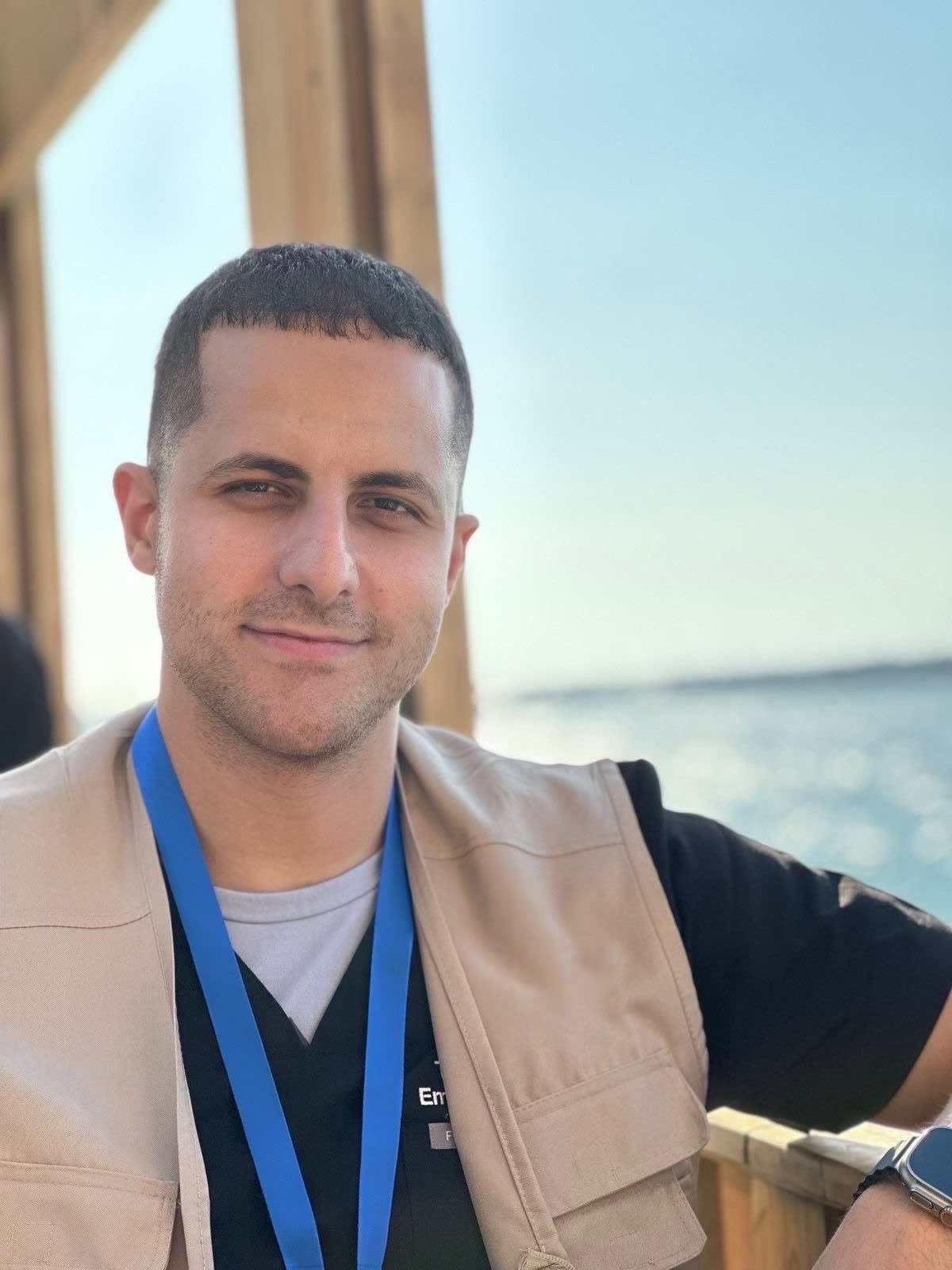 Dr. Thaer Ahmad, MD, wearing a field vest and lanyard over scrubs.
